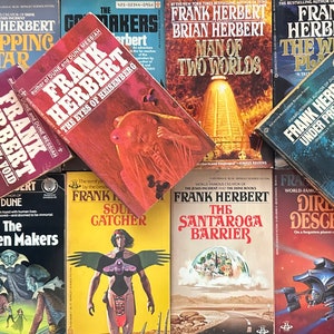 May include: A collection of science fiction paperback books by Frank Herbert, including "Dune", "Whipping Star", "The Santaroga Barrier", "Man of Two Worlds", "The White Plague", "Destination: Void", "The Eyes of Heisenberg", "Soul Catcher", and "Dire Descent".