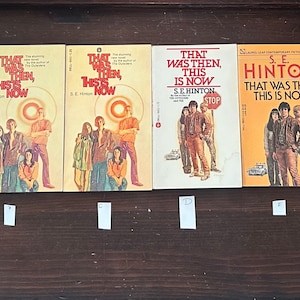 May include: Five paperback copies of the book "That Was Then, This Is Now" by S.E. Hinton. The covers feature different illustrations of the characters from the book.
