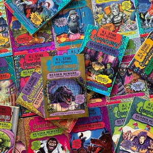 May include: A pile of Goosebumps books by R.L. Stine. The books have colorful covers with illustrations of monsters, creatures, and spooky scenes. The text on the covers reads "Give Yourself Goosebumps" and "Reader Beware... You Choose the Scare!"