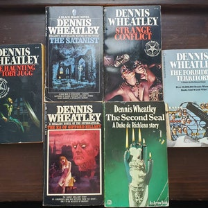 May include: A collection of six paperback books by Dennis Wheatley, a British author known for his horror and thriller novels. The books are titled "The Haunting of Toby Jugg", "The Satanist", "Strange Conflict", "The Forbidden Territory", "The Ka of Gifford Hillary", and "The Second Seal".