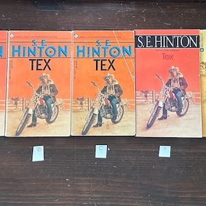 May include: Five paperback books with orange and yellow covers. The books are all titled "Tex" and feature a man riding a motorcycle on the cover. The author is S.E. Hinton, author of "The Outsiders".
