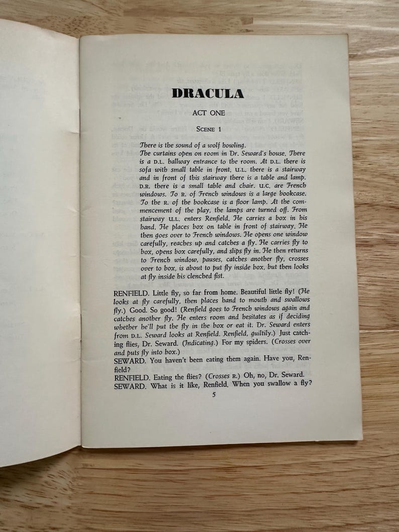 Może przedstawiać: Strona z drukowanego scenariusza zatytułowanego Dracula, Act One, Scene 1. Tekst opisuje scenę w domu doktora Sewarda z udziałem Renfielda, pudełka i much. Strona jest ponumerowana cyfrą 5 na dole i zawiera czarny tekst na białym tle.