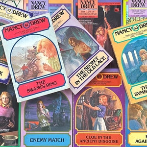 May include: A collection of Nancy Drew mystery books with colorful covers featuring various scenes and titles. The books are numbered 57, 60, 61, 69, 80, and 87. The titles include "The Swami's Ring", "The Secret in the Old Lace", "The Greek Symbol Mystery", "The Triple Hoax", "Clue in the Ancient Disguise", "Enemy Match", and "Race Against Time".