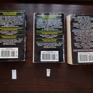 May include: Three paperback books with black covers and white text. The books are titled "Taltos" by Anne Rice. The back covers feature quotes about the book and author. The ISBN numbers are visible on the back covers.