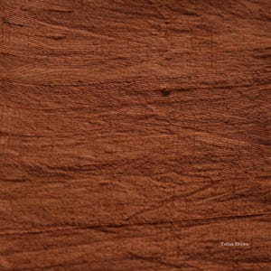 May include: Close-up of a textured fabric in a warm toffee brown color. The fabric has horizontal lines and a slightly uneven surface, with the words "Toffee Brown" in the bottom right corner.