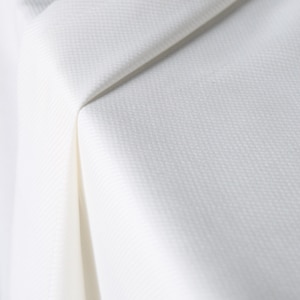 May include: Close-up of white fabric with a subtle textured pattern. The fabric is folded, creating shadows and highlighting the weave. The material appears to be lightweight and possibly suitable for clothing or home decor.