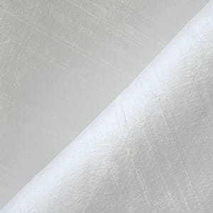 May include: Close-up of white fabric with a subtle, textured weave. The fabric is folded diagonally, revealing the texture and sheen of the material. The surface has a slight sheen, suggesting a luxurious or high-quality textile.