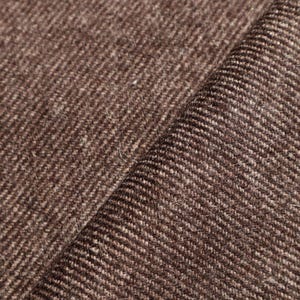 May include: Close-up of a brown and beige textured fabric with a subtle striped pattern. The fabric has a soft, fuzzy texture.