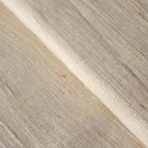 Könnte beinhalten: Nahaufnahme eines gefalteten Stoffes in Naturfarbe. Der Stoff hat ein strukturiertes, gewebtes Aussehen mit sichtbaren horizontalen und vertikalen Linien. Die Farbe ist hellbeige mit subtilen Farbvariationen.