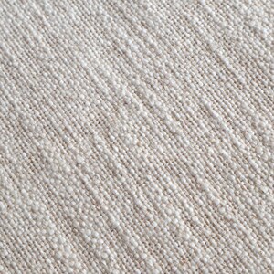 May include: Close-up of a natural linen fabric with a textured weave. The fabric is a light beige color.