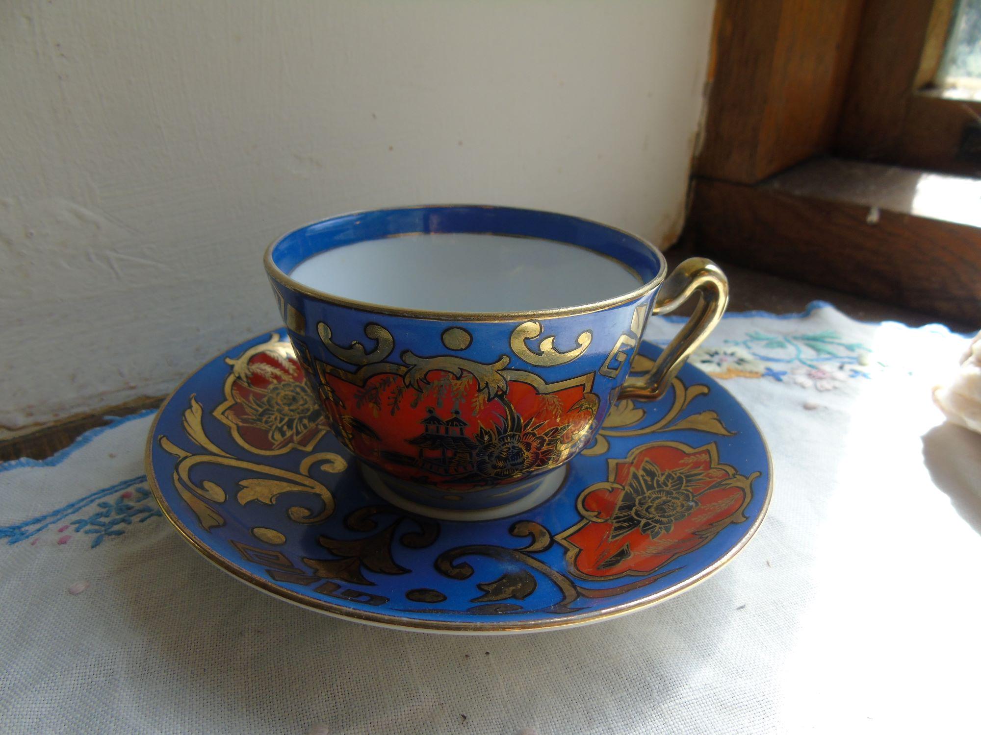 Noritake Gilded Cup and Saucer, decorated with flowers and Japanese Pagoda. In Blue, Red and gilded.