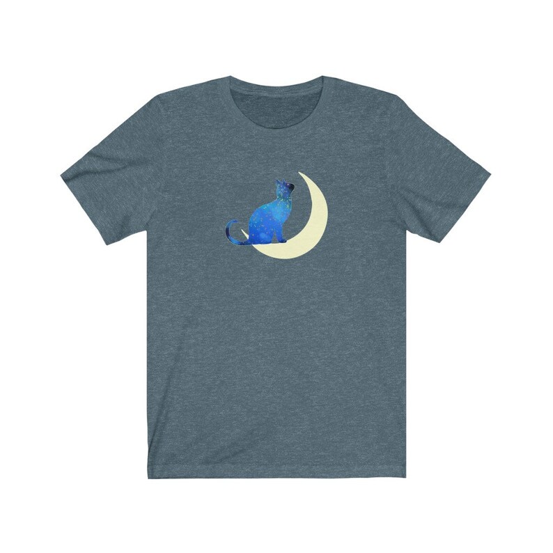 May include: A dark blue t-shirt with a blue cat sitting on a crescent moon. The cat and moon are both outlined in white.