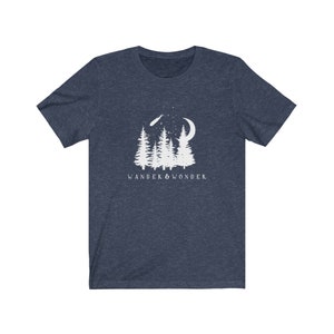 May include: A navy blue t-shirt with a white graphic of a crescent moon, shooting star, and pine trees. The text "WANDER & WONDER" is printed below the graphic.