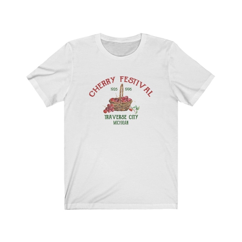 May include: White t-shirt with a red graphic of a basket of cherries and the text "CHERRY FESTIVAL 1926 1996 TRAVERSE CITY MICHIGAN".