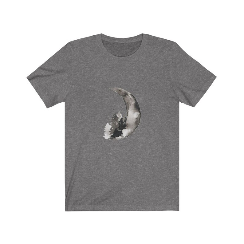 May include: A dark heather grey t-shirt with a black and white watercolor design of a crescent moon with a forest inside.