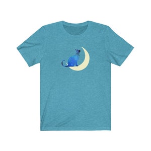 May include: A teal blue t-shirt with a graphic of a blue cat sitting on a crescent moon.