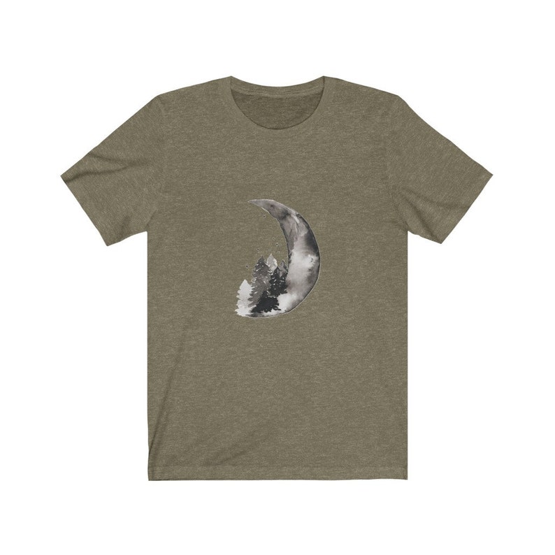 May include: A green t-shirt with a black and white watercolor design of a crescent moon with trees inside.