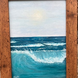 May include: A framed painting depicting a seascape with a blue sky and ocean waves breaking on the shore. The painting is signed "D. Watts" in the bottom left corner.