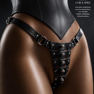 May include: A black leather lingerie set with studded detailing. The image includes the text "LEATHER. POWER. DESIRE." and "DARE TO WEAR. BORN TO STAND OUT." The set features a high-waisted bottom.