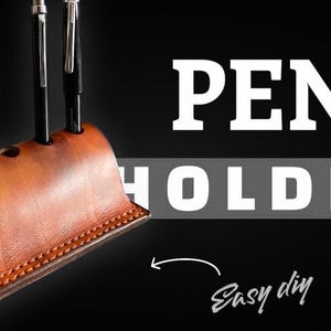 K&ouml;nnte beinhalten: Ein handgefertigter brauner Leder-Stifthalter mit drei Stiften. Der Stifthalter hat ein geschwungenes Design mit einem gen&auml;hten Rand. Die Worte "PEN HOLDER" sind in gro&szlig;en wei&szlig;en Buchstaben auf schwarzem Hintergrund zu sehen, mit "Easy diy" in Kursivschrift.