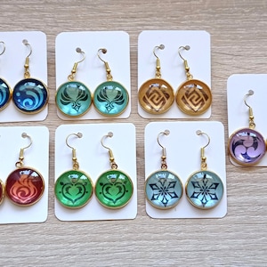 May include: Ten pairs of gold-tone earrings with various colored glass cabochons. Each pair features a different design, including geometric shapes, swirls, and floral patterns.
