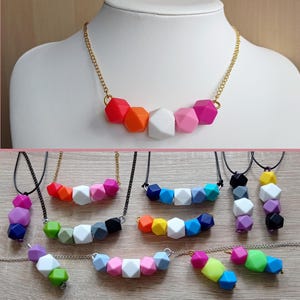 May include: A set of colorful necklaces featuring geometric silicone beads. The necklaces are available in a variety of colors, including red, orange, yellow, green, blue, purple, and white. The beads are all in the shape of a dodecahedron.
