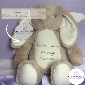 May include: A plush beige rabbit toy with long ears and white accents on the ears and feet. The chest features embroidered text that reads Love you always Nanna. A circular tag with the text Cloud 9 Crafts Personalised Gifts is attached.