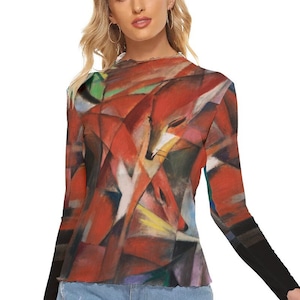 Puede incluir: Top de manga larga con un dise&ntilde;o abstracto de zorro en tonos rojos, naranjas y blancos. La obra de arte recuerda al cubismo. El top tiene un cuello alto y mangas negras.
