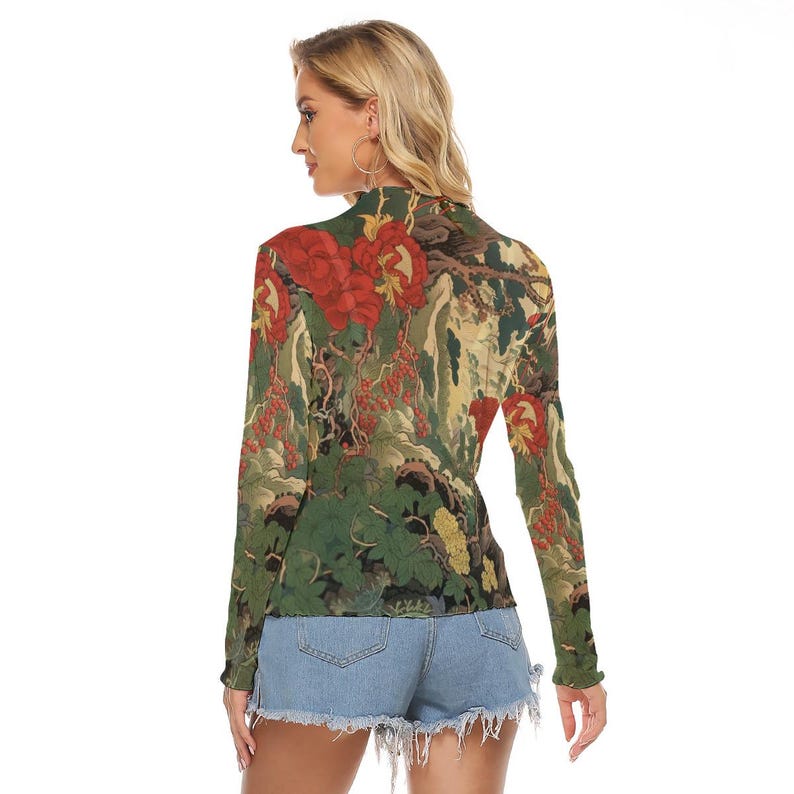 Peut inclure: Un haut &agrave; manches longues avec un col montant, orn&eacute; d'un motif floral dans les tons de rouge, vert et jaune. Le design comprend de grandes fleurs rouges et une impression d&eacute;taill&eacute;e inspir&eacute;e de la nature. Le haut est port&eacute; avec un short en jean.