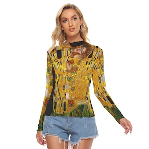 May include: A long-sleeved shirt with a black background and a colorful print of a painting. The print features two figures embracing, with a gold and yellow background.