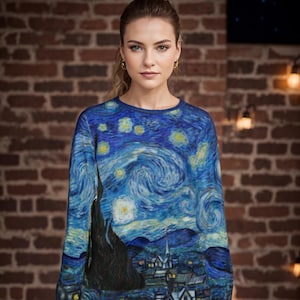 Op de afbeelding: Een blauwe en gele trui met een print van Vincent van Gogh's schilderij "De Sterrennacht".