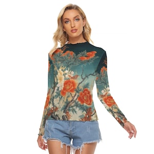 May include: A long-sleeved top featuring a floral design with orange and white flowers on a teal background. The top has a high, ruffled neckline and is paired with denim shorts. The floral pattern extends across the sleeves.