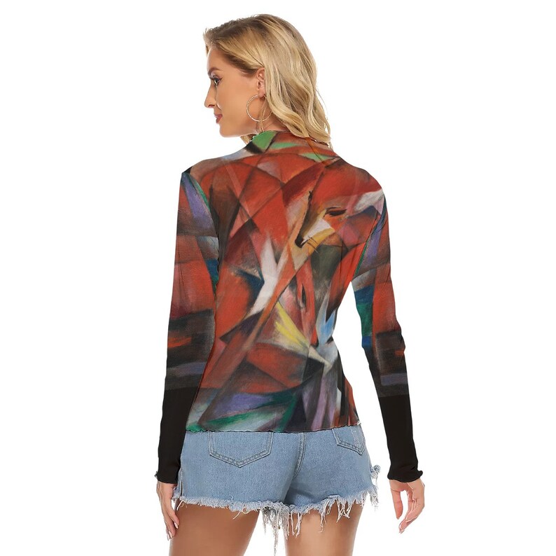 Puede incluir: Una camiseta de manga larga con cuello alto y un dise&ntilde;o abstracto de zorro en tonos rojos, naranjas y blancos. Las mangas son negras y la camiseta se combina con pantalones cortos de mezclilla. La obra de arte tiene un estilo geom&eacute;trico.