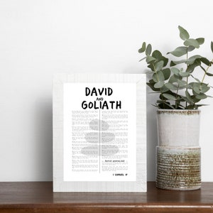 May include: A framed black and white print with the text "DAVID AND GOLIATH" and a passage from the Bible. The text "David prevailed 1 SAMUEL 17" is at the bottom of the print.