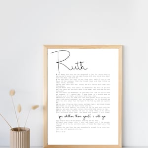 May include: A framed black and white print with the text "Ruth" in a large, handwritten font. The print features a passage from the Book of Ruth in the Bible, verses 1:8-18.