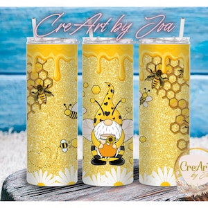 May include: Three yellow glitter tumblers with bee and honeycomb patterns. One tumbler has a gnome holding a honey pot. The tumblers have a yellow dripping honey design at the top and the text "Cre Art by Joa".