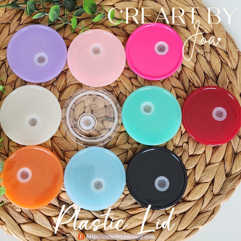 Puede incluir: Surtido de diez tapas de pl&aacute;stico en varios colores, incluyendo morado, rosa, beige, transparente, turquesa, rojo, naranja, azul claro, negro y blanco. Las tapas est&aacute;n dispuestas en c&iacute;rculo sobre una superficie de mimbre tejido. El texto "CREARTBY JOA" es visible en la parte superior de la imagen, y el texto "Plastic Lid" es visible en la parte inferior de la imagen.