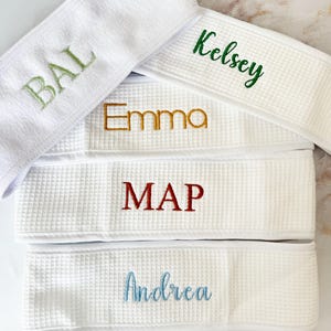 May include: A handmade wooden sign with the text "Welcome to our home" in a handwritten style. The sign is painted white with a dark stained wooden frame. The sign measures approximately 12 inches wide and 8 inches tall.