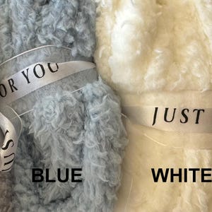Puede incluir: Cuatro mantas esponjosas en gris, azul, blanco y marfil. Cada manta est&aacute; atada con una cinta que dice "Just for you".