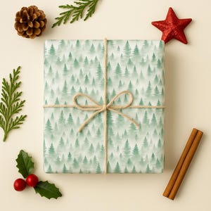 Könnte beinhalten: Ein rechteckiges Geschenkpaket, eingewickelt in Papier mit einem wiederkehrenden Muster aus grünen Tannenbäumen. Das Paket ist mit einer dünnen beigen Schnur zu einer mittigen Schleife gebunden. Drumherum liegen ein Tannenzapfen, ein roter Stern, grünes Blattwerk und Zimtstangen.