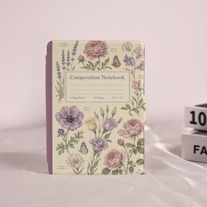 May include: A cream-colored composition notebook featuring a botanical print of purple and pink flowers, lavender sprigs, and butterflies. The center label reads Composition Notebook, College Ruled, 120 Pages, 8.5 x 11 inches. The spine is purple.