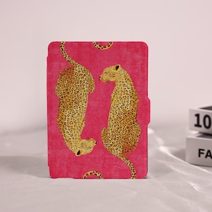 May include: A rectangular tablet case featuring a vibrant pink background with a repeating pattern of two yellow and black spotted leopards. The leopards are positioned vertically, one facing downward and the other facing upward, covering the surface.
