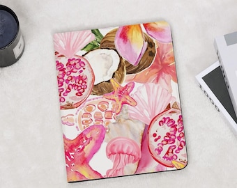 Può includere: Un taccuino con un design ad acquerello con fiori rosa e gialli, melograni, stelle marine e conchiglie. La copertina ha uno sfondo bianco con un bordo nero.