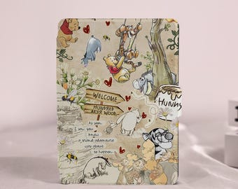 May include: A beige case with illustrations of Winnie the Pooh characters. The design includes a welcome sign for Hundred Acre Wood, bees, hearts, and the text "As soon as I saw you knew a grand adventure was about to happen."