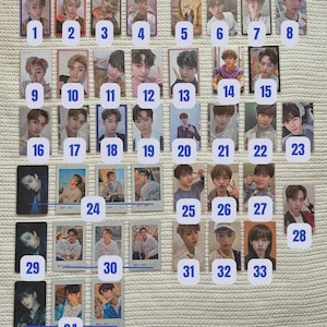 Puede incluir: Una colección de 34 tarjetas coleccionables con retratos de personas y números. Las tarjetas están dispuestas sobre una superficie clara, con texto "STAY" y "PA" en algunas tarjetas.