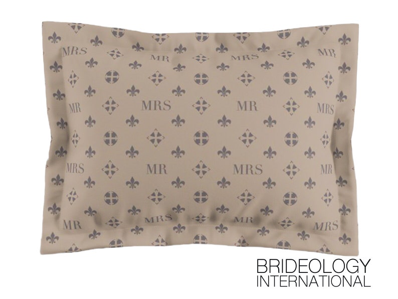 Puede incluir: Funda de almohada beige con un patr&oacute;n repetido de flores de lis y las palabras "MR" y "MRS" en gris.