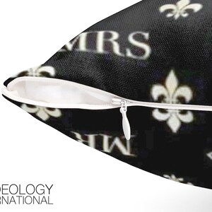 May include: Black and white pillow with a zipper closure. The pillow has a repeating pattern of the words "Mr." and "Mrs." and a fleur-de-lis design.