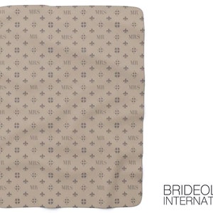 Puede incluir: Una tela beige con un patr&oacute;n repetitivo de las palabras "MR" y "MRS" en un color marr&oacute;n claro. El patr&oacute;n tambi&eacute;n incluye un dise&ntilde;o estilizado de flor de lis. El texto "BRIDEOLOGY INTERNATIONAL" est&aacute; impreso en la esquina inferior derecha.
