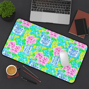 May include: A yellow, blue, and pink floral patterned mouse pad with a white computer mouse on top. The pattern features blue and white porcelain vases with floral designs and pink flowers.