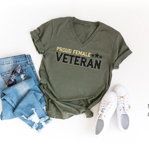 a shirt that says proud female veteran next to a pair of jeans
